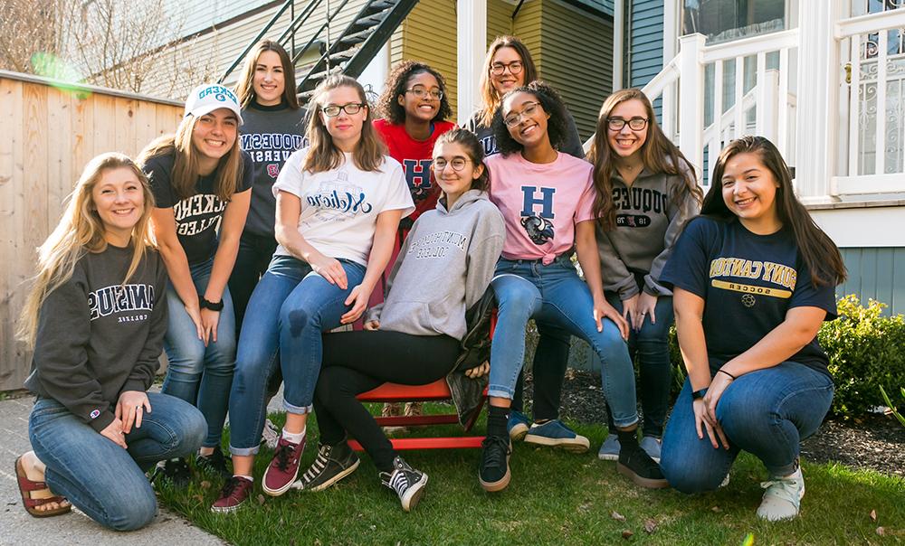 students posing in their college shirts in the courtyard